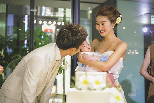かわいい友人の赤ちゃんを抱っこする花嫁