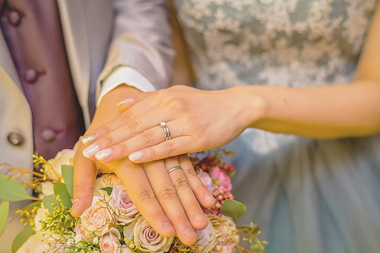 2人の手に輝く結婚指輪